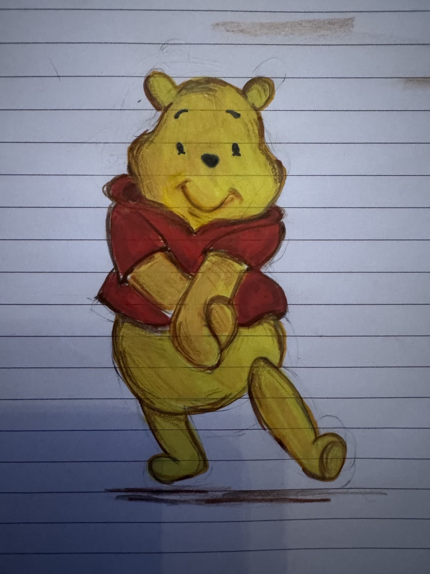A smiling Winnie the Pooh in his red shirt, in coloured pencil on lined paper
